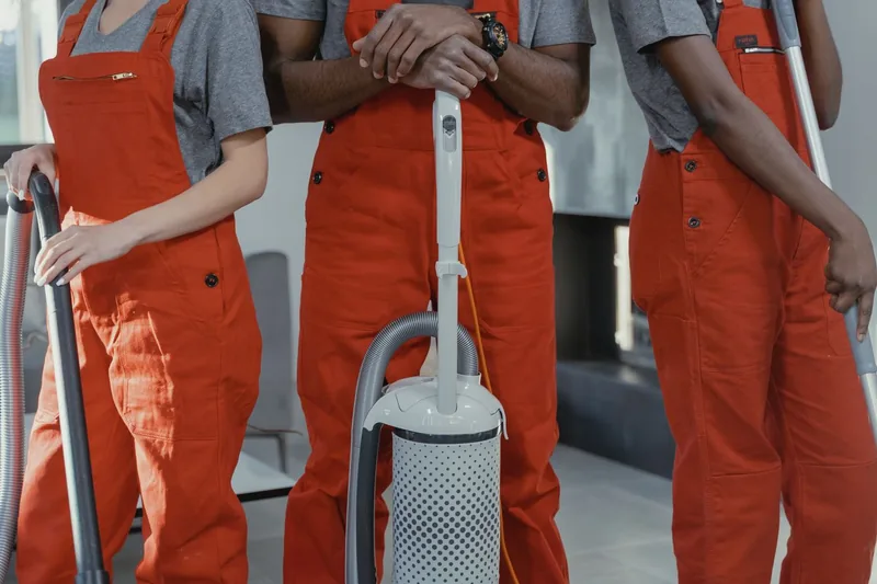 Cleaning team with a vacuum cleaner and supplies